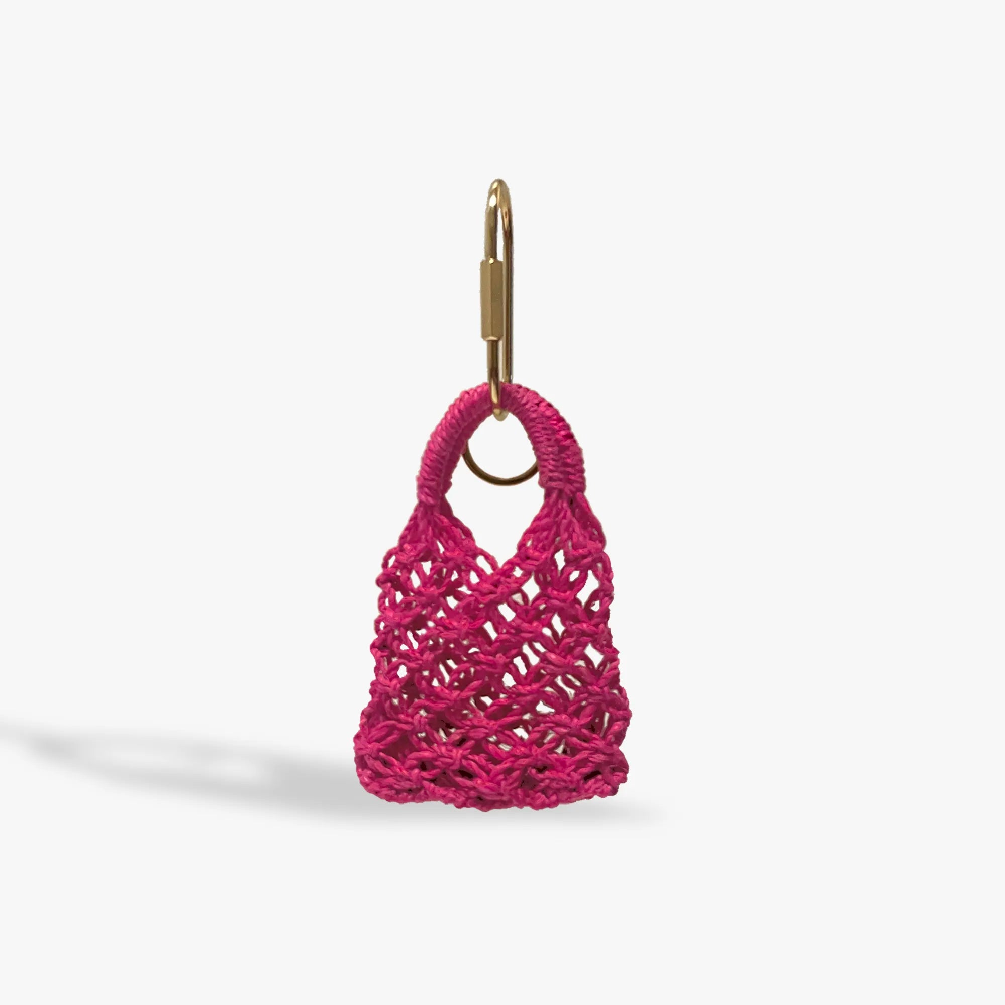 Pink woven bag keychain on a white background
