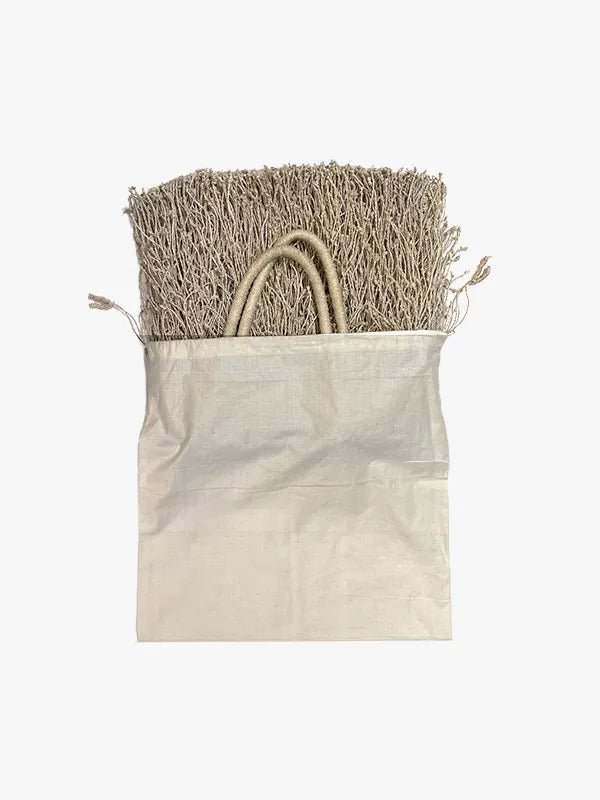 Beige woven bag with fringe on a white background