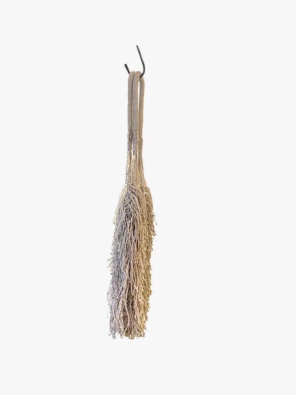 Broom hanging on a hook against a white background