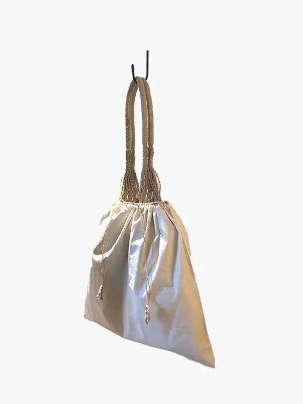 Beige drawstring bag with a rope handle on a white background