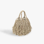 Beige woven handbag with fringe details on a white background