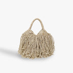 Beige handbag with fringe details on a white background